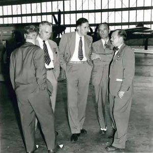 Men standing in hangar.