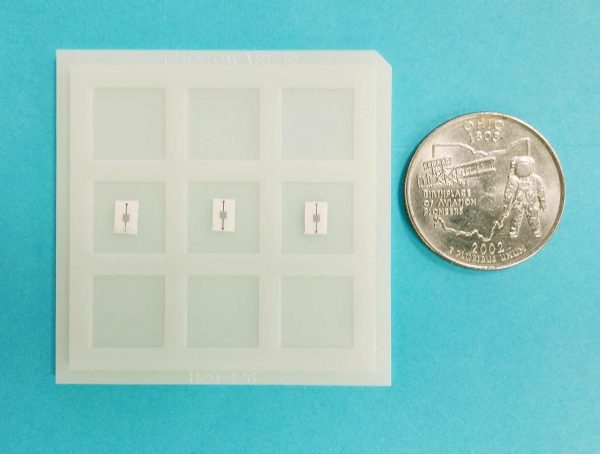 Photo of a carbon dioxide electrochemical cell microsensors next to a coin for comparison.