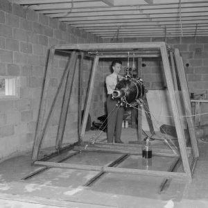 Man prepares rocket engine in test cell.
