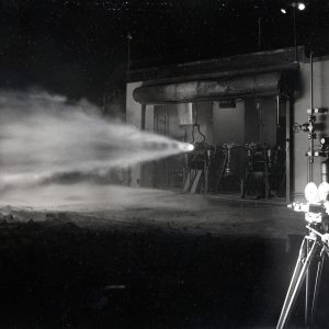 Camera man filming horizontal rocket firing at night.