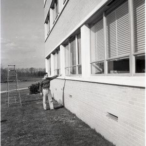 Man inspecting broken windows.