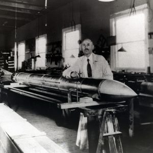 Robert Goddard with rocket on a horizontal stand.