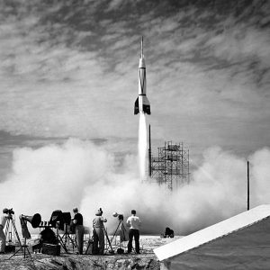 Rocket launch with camera men in the foreground.