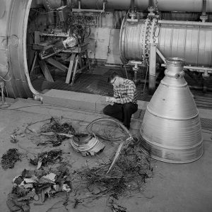 Engineer examines damaged rocket engine in front of PSL No.1 chamber.