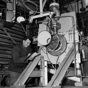 A mechanic checks on an engine setup at J-1