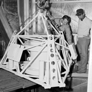 Mechanics install a replica of the Surveyor spacecraft to the Atlas-Centaur rocket in E Stand