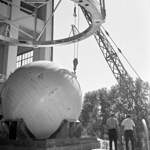 Crane lifts round tank into K Site building
