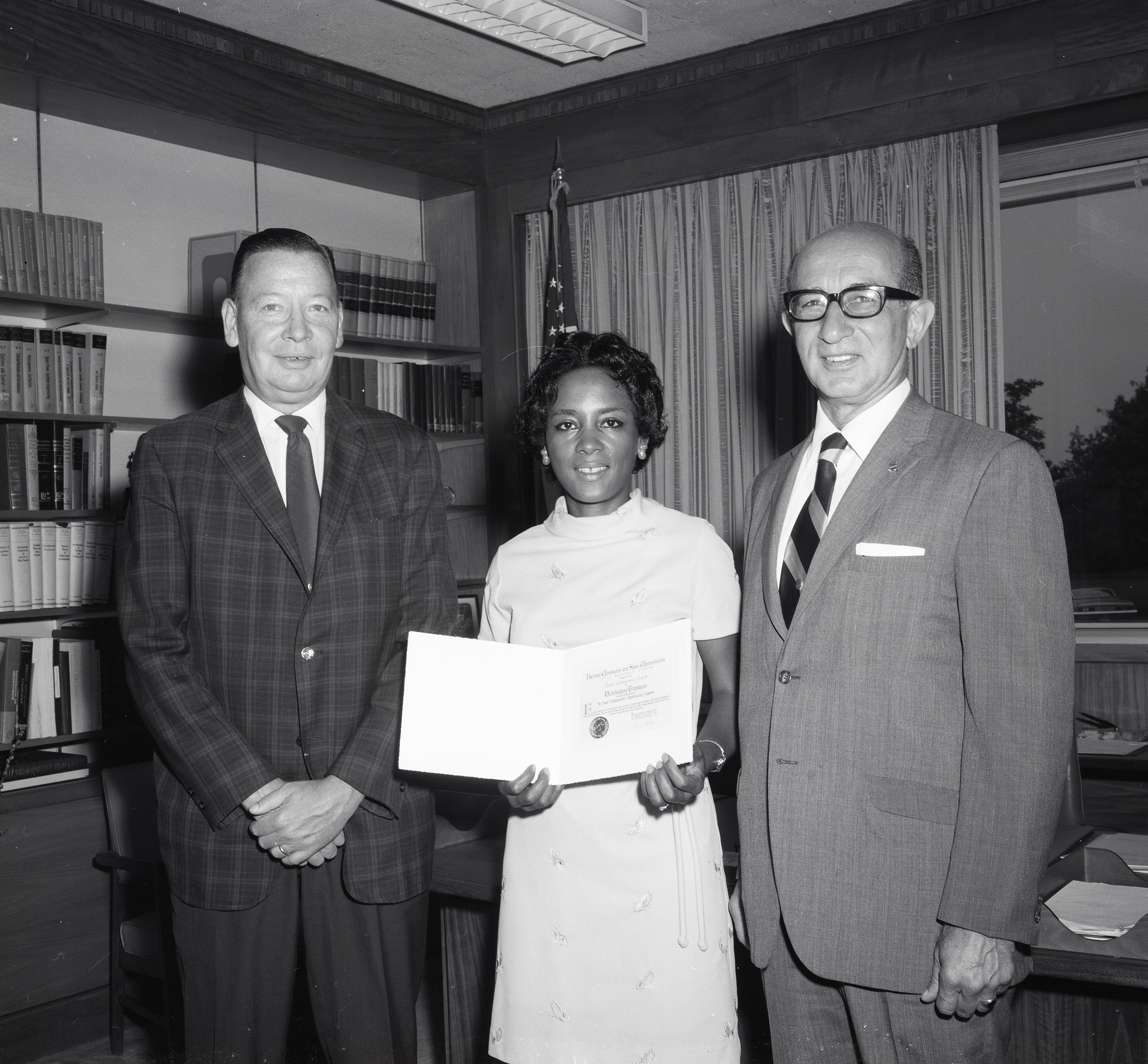 Annie Easley poses with her Special Achievement Award with Director of Administration Henry Barnett on her left and Deputy Director Gene Manganiello on her right.