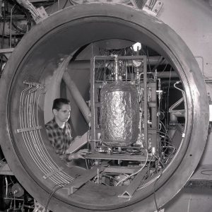 Man with engine in test chamber.