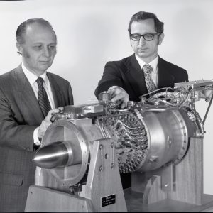 Two researchers pose with Low Cost Engine