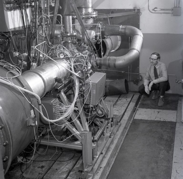 Researcher with engine in test cell.