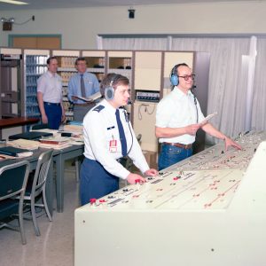 Four men in control room conducting test