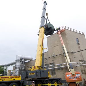 Crane lifts drive motor from roor of Exhauster Building.
