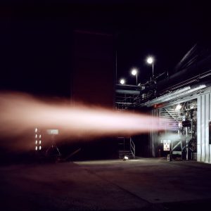 Rocket engine firing horizontally out of J-1 at night