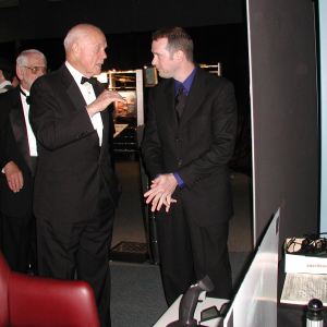 John Glenn and another stand talking.