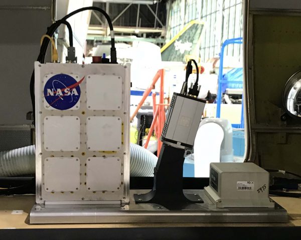 View from inside the NASA Twin Otter aircraft of the Hyperspectral imager installed. View of the hangar outside the aircraft door behind the imager.