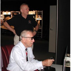 Apollo 13 flight director, Gene Kranz, watches Jim Lovell pilot WrightSim.