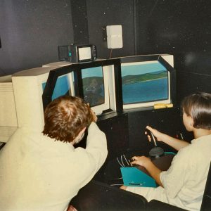 Man showing young boy how to use flight simulator.