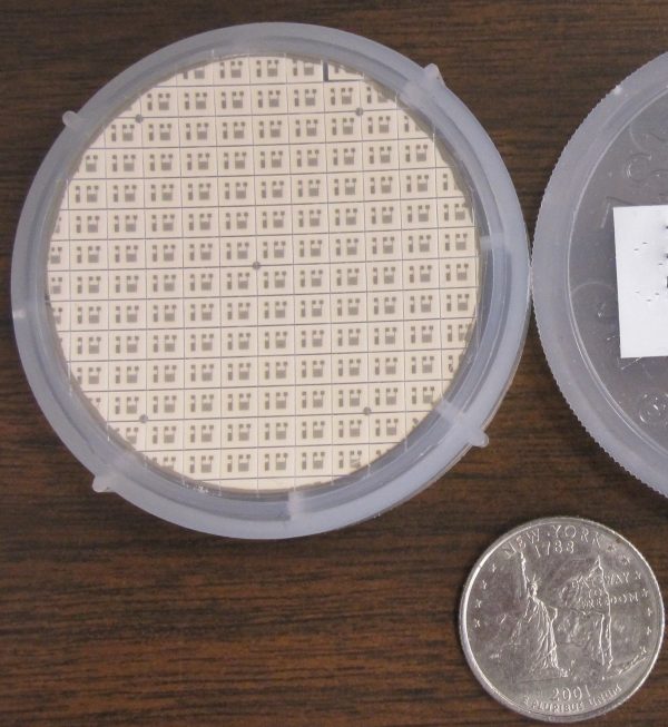 Photo of a microfabricated room temperature O2 sensor next to a coin for comparison.