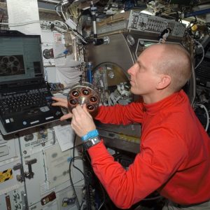 Expedition 15 Flight Engineer, Astronaut Clay Anderson examines the sample carousel configuration during the Smoke and Aerosol Measurement Experiment (SAME) hardware set up on board ISS.