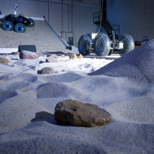 Two roving vehicles traversing simulated lunar terrain in the SLOPE Lab