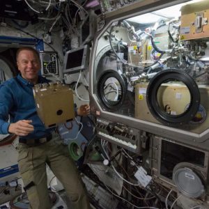Expedition 47 Commander Tim Kopra stows hardware from the Observation and Analysis of Smectic Islands In Space (OASIS) investigation aboard the International Space Station. OASIS studies the unique behavior of liquid crystals in microgravity.
