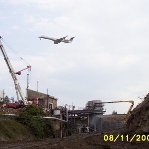 Demolition site with airliner flying over